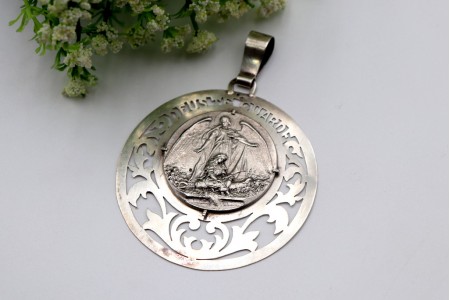 Medalha em prata com figura de Anjo da Guarda e criança 
