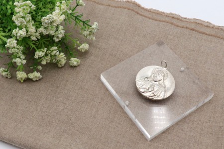 Medalha de prata com representação do Sagrado Coração de Jesus em alto relevo