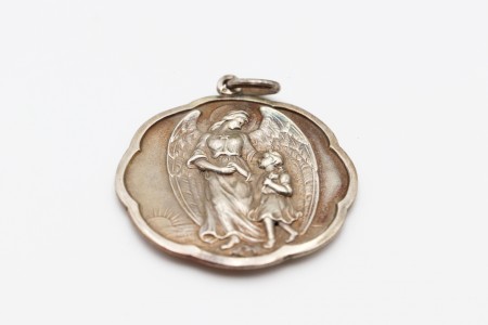 Medalha em prata com friso e aplicação figura de Anjo da Guarda e criança 