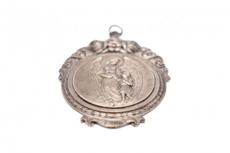 Medalha em prata com figura de anjo da guarda e criança, bordos em alto relevo