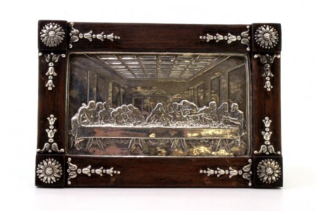 Moldura em pau santo envolvendo a última ceia em prata com aplicações.