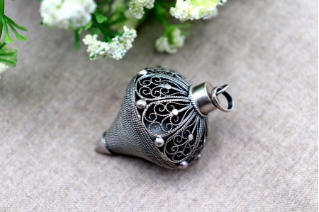 Pião em prata de filigrana com aplicações e argola de suspensão.