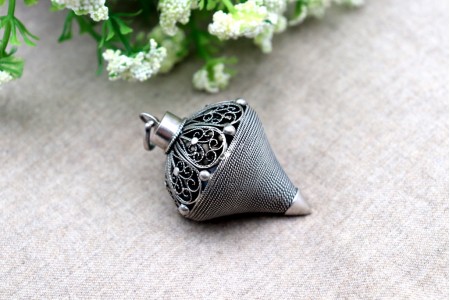 Pião em prata de filigrana com aplicações e argola de suspensão.