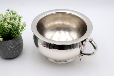 Penico em prata lisa com pega relevado com enrolamentos.