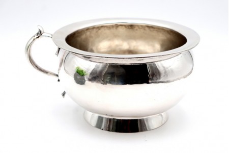 Penico em prata lisa com pega relevado com enrolamentos.