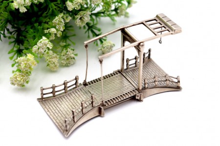 Miniatura de ponta elevatória em prata com relevos e aplicações