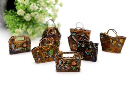 Nove bolsinhas em miniatura de prata dourada com aplicações de esmalte.