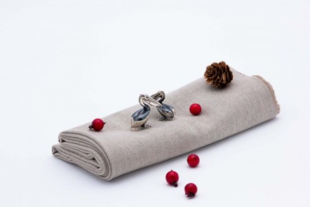 Par de pelicanos em prata nielada em posição de sentados.