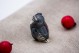 Miniatura de coruja em prata nielada em posição sentada.
