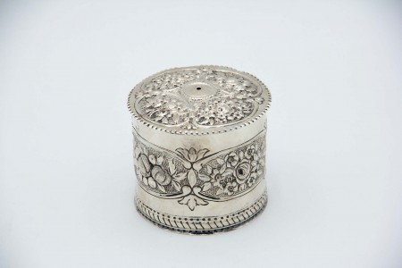 Caixa em prata para rolo de cordel ou lã com relevos alusivos a flores e frisos ondeados na tampa.