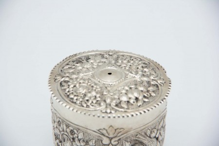 Caixa em prata para rolo de cordel ou lã com relevos alusivos a flores e frisos ondeados na tampa.