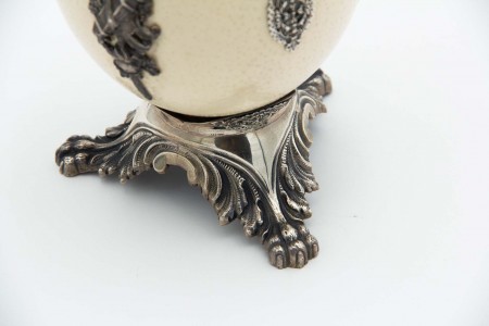 Ovo de avestruz assente em três pés de suporte em prata