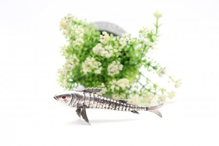 Peixe em prata articulada com duas pedras vermelhas nos olhos