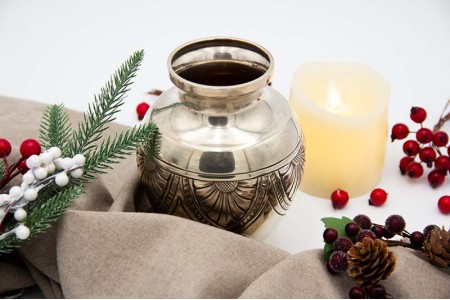 Pote em prata de formato bojudo com motivos florais gravados.