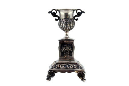 Paliteiro em prata com taça sobre pedrestal com motivos florais em base quadrada com quatro pés.