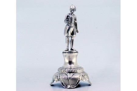 Paliteiro em prata com figura de chefe Turco em pé sobre plinto que assenta em pedestal relevado com quatro pés.