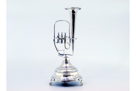 Paliteiro em prata com com tuba sobre pedestal e assente em três pés em forma de folha.