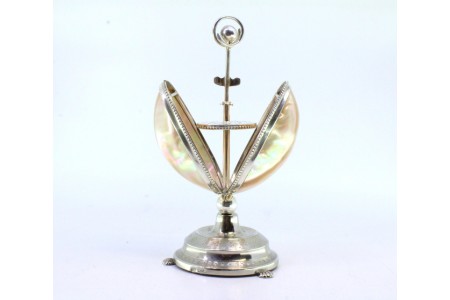 Paliteiro em prata com forma de ostra assente em base circular com relevos, sistema de pressão para abertura