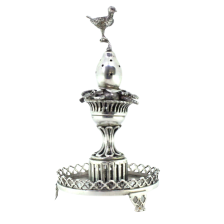  Paliteiro em prata com aplicações, ave poisada sobre fruto no cimo de cesto de fruta e assente em plinto recortado sobre base redonda com três pés.