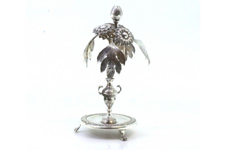 Paliteiro em prata com aplicações de flores e folhas de acanto suportado por jarra assente em base frisada 