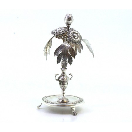  Paliteiro em prata com aplicações de flores e folhas de acanto suportado em por jarra com assente em base frisada com três pés em forma de garras.