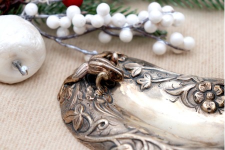 Paliteiro em prata com relevos eaplicações de sapos e motivos florais revelados.