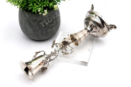  Paliteiro em prata com cálice sobre aplicações de trepadeira com folhas de acanto em base circular com gravados e três pés recortados.