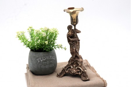  Paliteiro em prata com cálice em dourado em folhas de acanteiro e figura feminina como suporte, sobre base trípode recortada com mascarões e enrolamentos.