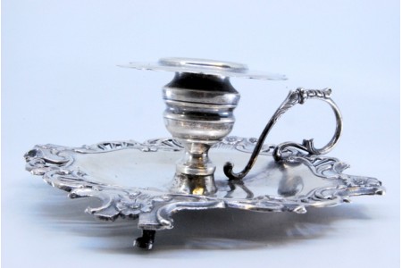 Palmatória em prata com flores relevadas e assente sobre três pés.