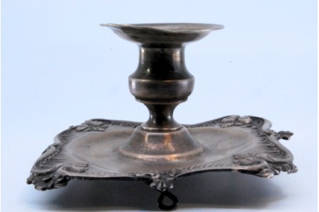 Palmatória em prata com base lisa e rebordo com relevos.