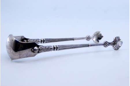 Pinça de açúcar em prata canelada com relevos em forma de folhas.