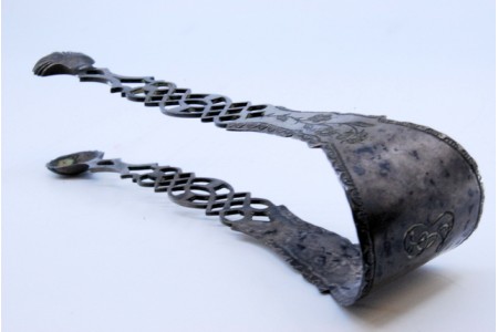 Pinça de açúcar em prata recortada com flores e pinças em forma de conchas.