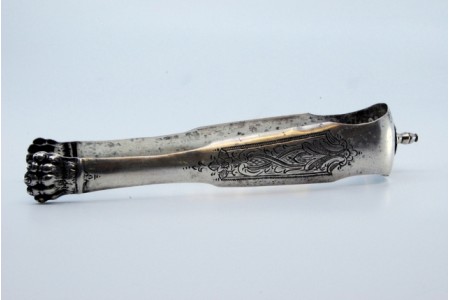 Pinça para gelo em prata em forma de garras com gravados e aplicação.