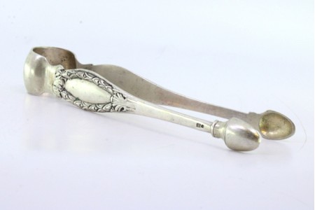 Pinça de açúcar em prata com relevos e cartelas para monogramas.