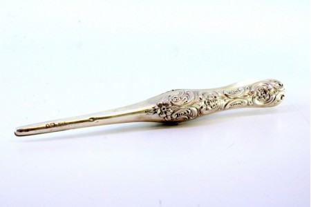 Pinça para alargamento de luvas em prata com relevos nos cabos.