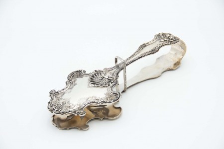 Pinça em prata relevada com conchas e frisos, motivos florais gravados e recorte