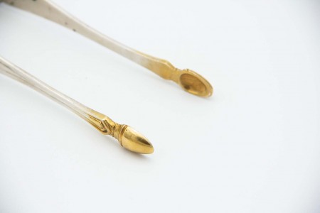 Pinça para açúcar em prata com pontas douradas.