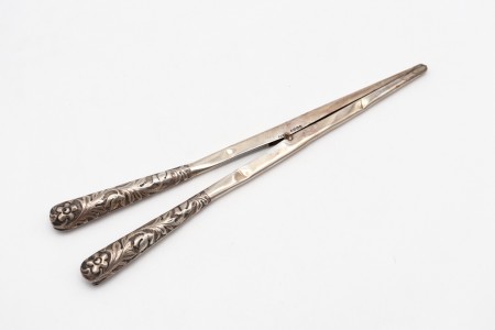 Pinça esticadora de luvas em prata com relevos vegetalistas no cabo