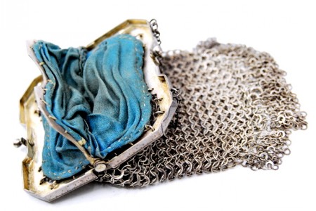 Porta moedas em malha de prata com interior forrado a tecido azul.