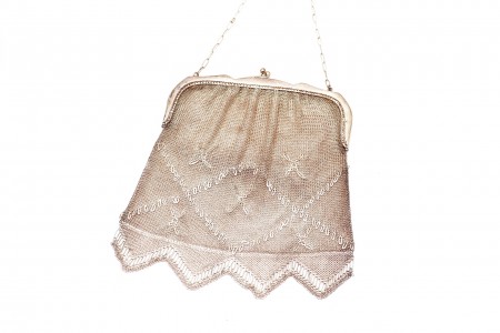 Bolsa em malha de prata com padrões decorativos, cadilhes suspensos e corrente