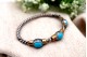 Pulseira em prata e ouro em formato retorcido e três cabochões azuis