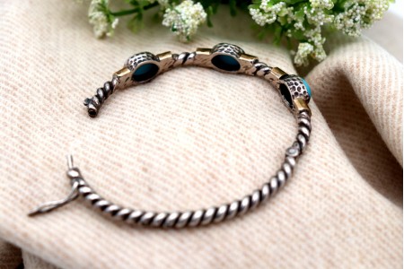 Pulseira em prata e ouro em formato retorcido e três cabochões azuis