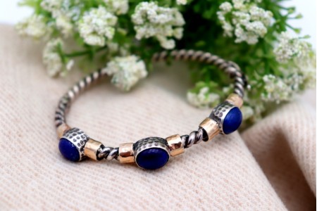 Pulseira em prata e ouro em formato retorcido e três cabochões azul escuro