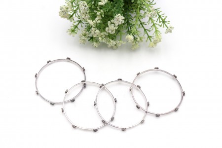 Conjunto de quatro pulseiras tipo escrava em prata lisa e adornadas com flores e