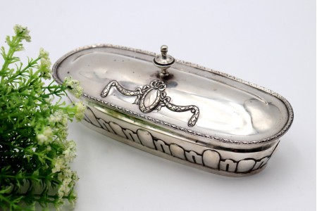 Saboneteira em prata com relevos frisados e laço envolvendo cartela 