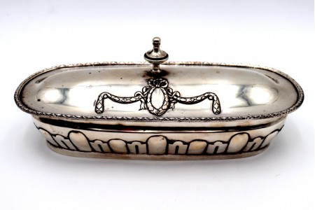 Saboneteira em prata com relevos frisados e laço envolvendo cartela 