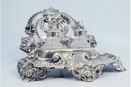  Tinteiro em prata recortada, dois depósitos em vidro facetado com volutas e conchas.