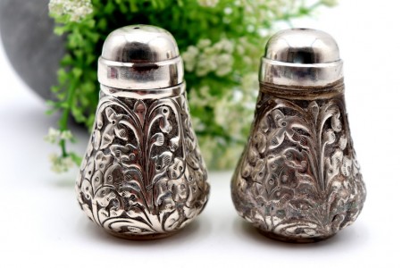 Conjunto de saleiro e pimenteiro bojudos com relevos florais e tampas de roscas
