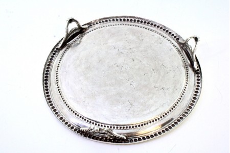 Salva-bilheteira em prata com frisos perlados na envolvência e motivos florais gravados, assente em três pès recortados.