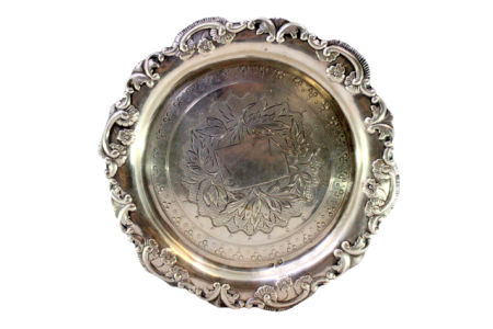 Salva/bilheteira em prata com relevos e motivos florais gravados envolvendo cartela para monograma, assente em três pés recortados.